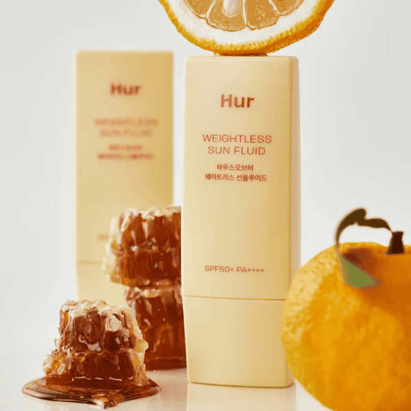 Nøglering, vægtløs solcreme i æske med SPF 50+ for ansigt og krop, fransk hudpleje, med citrusfrugt baggrund, naturlig og beskyttende solbeskyttelse, hudpleje til alle hudtyper.