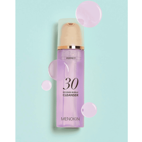Billedtekst, der viser en Menokin 30 Seconds Bubble Cleanser-flaske med plejende skum til rensning af huden, perfekt til en frisk hudplejerutine.
